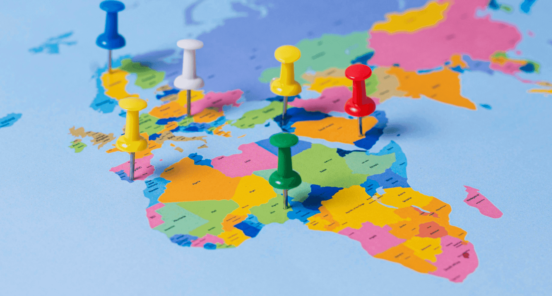 Een wereldkaart met punaises die op verschillende landen geplaatst zijn.