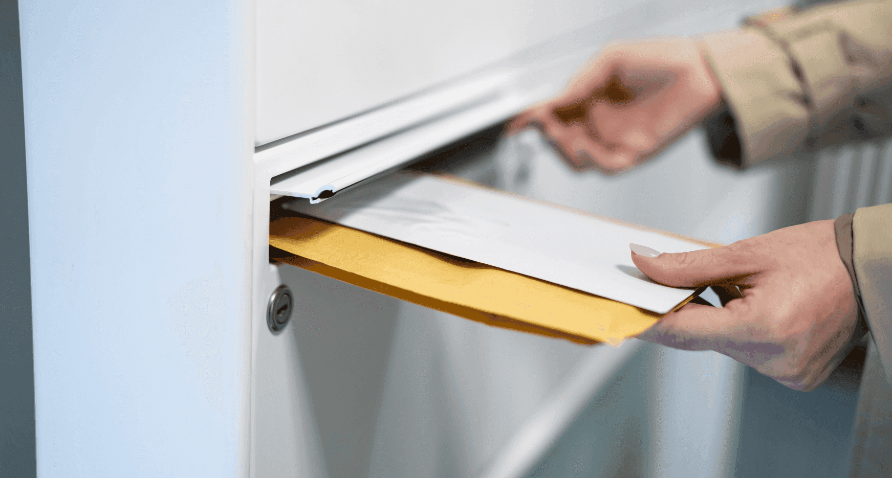 In de brievenbus van een deur zitten twee enveloppen die door een persoon uit de brievenbus gehaald worden.