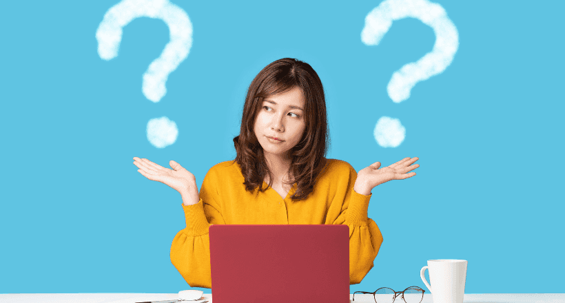 Een vrouw zit achter een laptop. De achtergrond is lichtblauw. Ze steekt twee handen op waar witte vraagtekens bovenstaan. Ze heeft vragen over hoe ze verzekeraars kan vergelijken